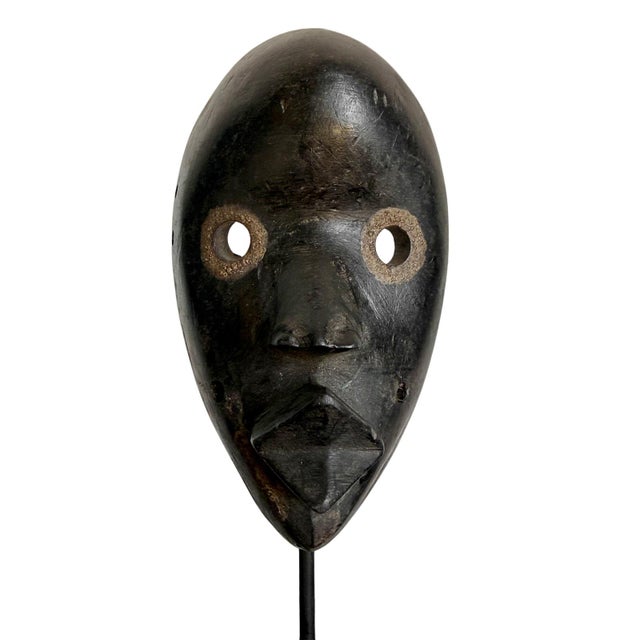 Original Dan passport mask mounted on iron and wood display stand. This small mask is carved in lightweight wood and dyed...