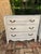 Pair of distressed white French chests or bedside tables. Distressed white finish, 3 drawers, metal/ brass hardware.