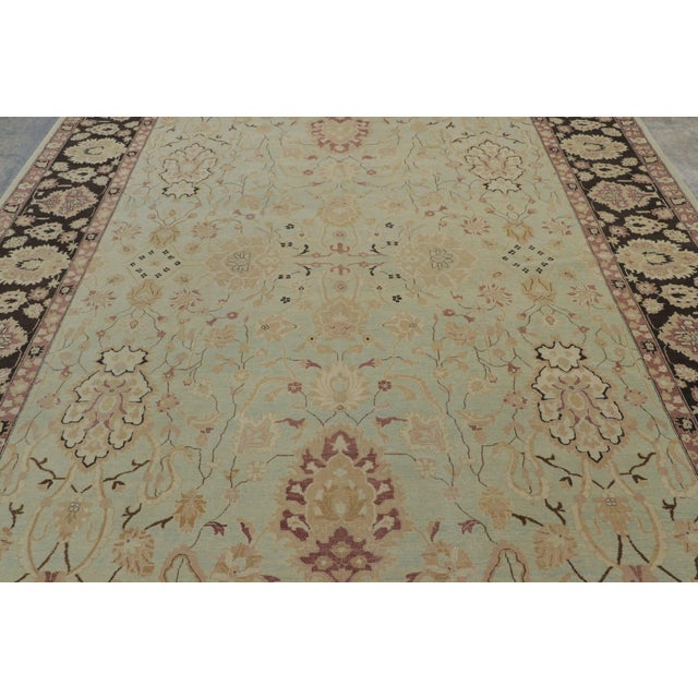 Hand-knotted in wool circa 1950-1960, this 9x12 vintage Agra rug is a majestic example of the fabled Indian weaving...
