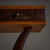 Console table with a tinted glass top with three dark brown leather-covered drawers, accented by brass knobs and...