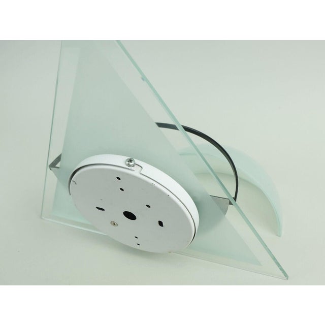 A pair of 1980s sconces by lamperti, model illo. Triangular back and half-shell-shaped shade made of etched, slightly...