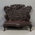Antique dark red lacquer, Meiji period, Japanese settee featuring a heavily carved dragon and Iris motif. The pierced...