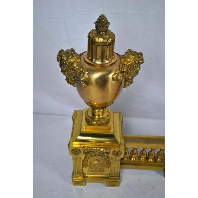A large elaborate french ormolu on brass fire fender with fire urns in the centre moving to the heads of bacchus on each...