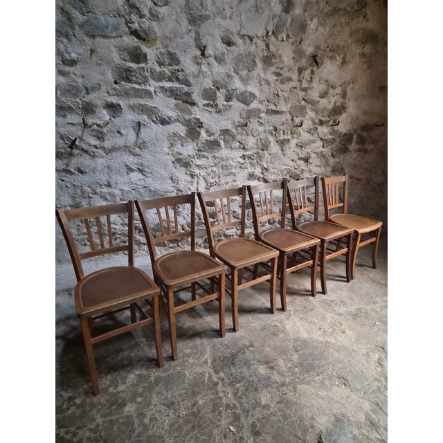 This set of six vintage bistro chairs dates from the 1950s and originates from France. Made of beech wood, the chairs...