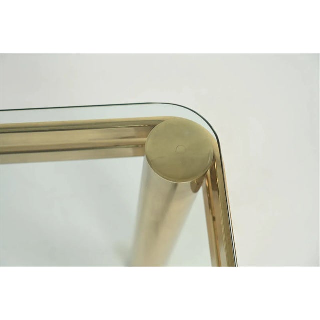 a 1970's brass finish tubular console table with rounded edge glass top designed in the manner of Leon Rosen for Pace...