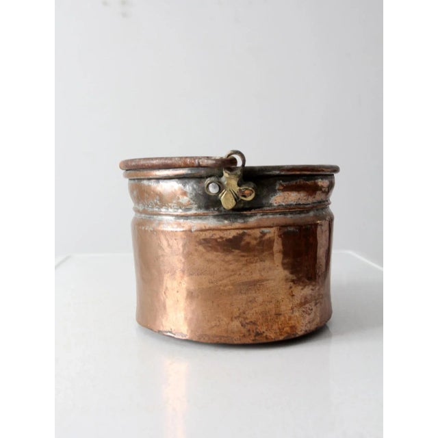 This is a 19th century antique copper bucket. The copper bucket features an iron bail handle with brass hardware. A...