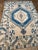 A lovely vintage Oushak rug. This vintage Oushak offers a cream palette with blue and light blue accents.