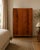 A handsome 1950s double wardrobe with richly figured flame mahogany doors, decorative moulding, ornate drop handles and...