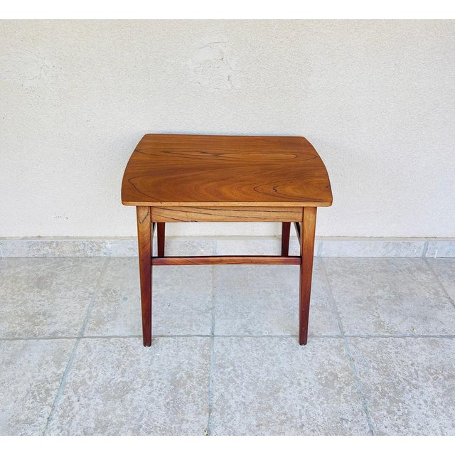 Stunning walnut console table, showcasing an elegant 1960s Scandinavian design. Its gently curved top highlights the rich,...