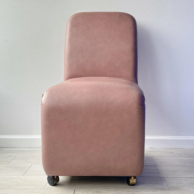 Vintage late 20th century rolling chair by Design Institute of America (DIA) in a mauve faux leather fabric that is the...