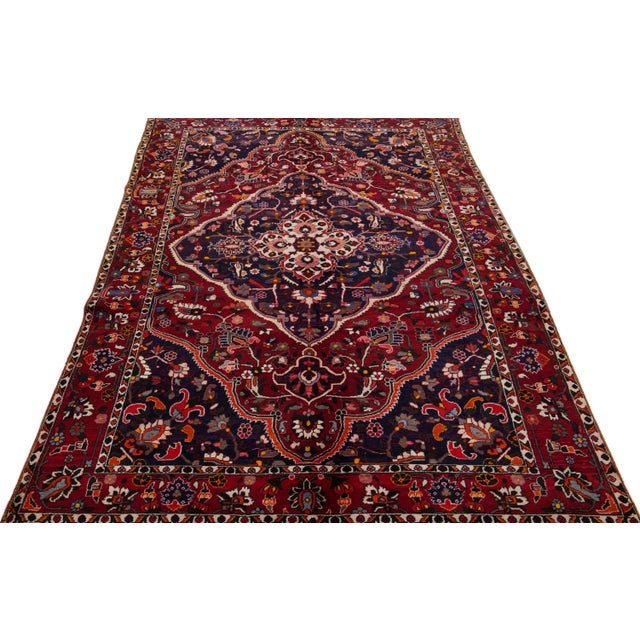 Beautiful Antique Bakhtiari hand-knotted wool rug with a burgundy field. This Persian piece has an all-over multicolor...