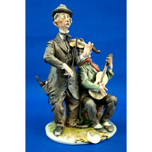 Polychrome and vitrified hard-paste porcelain sculpture depicting a pair of elderly begging musicians, entirely hand-...