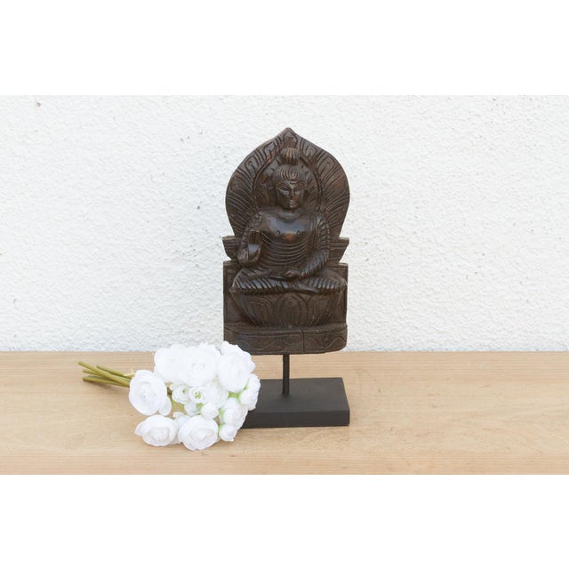 A soulful piece of devotional folk art, this carved wooden sculpture depicts the Buddha seated in meditation. The right...