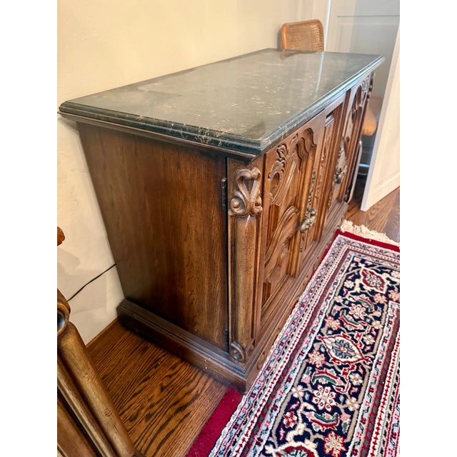 A beautifully characterful piece that brings Old World elegance to any space. This carved oak sideboard features a...