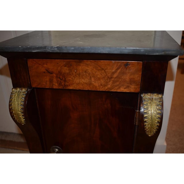 Empire or Directoire Continental commode stand circuit 1810 to 1830s. This intriguing example holds a veined gray marble...
