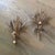A charming pair of vintage Italian gilt iron wall candle sconces featuring sculptural wheat sheaves, gracefully scrolling...