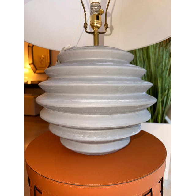 Contemporary ceramic table lamp featuring a sculptural ribbed gray ceramic base that adds texture and dimension to its...