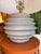 Contemporary ceramic table lamp featuring a sculptural ribbed gray ceramic base that adds texture and dimension to its...