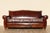 Spectacular vintage Art Deco three-seat sofa upholstered in rich distressed brown leather, featuring an elegant sculptural...