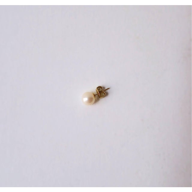 A single white cultured pearl earring with 14-karat yellow gold post. A single earring great for a first or second hole....