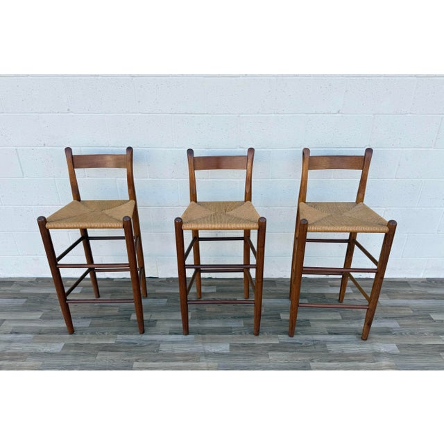 Beautiful vintage set of three Danish Modern style bar stools, circa 1970s, crafted with solid wood frames and handwoven...