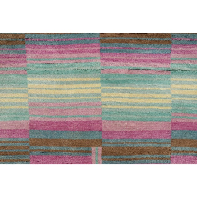 This 4x7 Mid-Century Modern rug showcases a bold abstract design in sky blue, pink, camel, and ivory. Layered geometric...