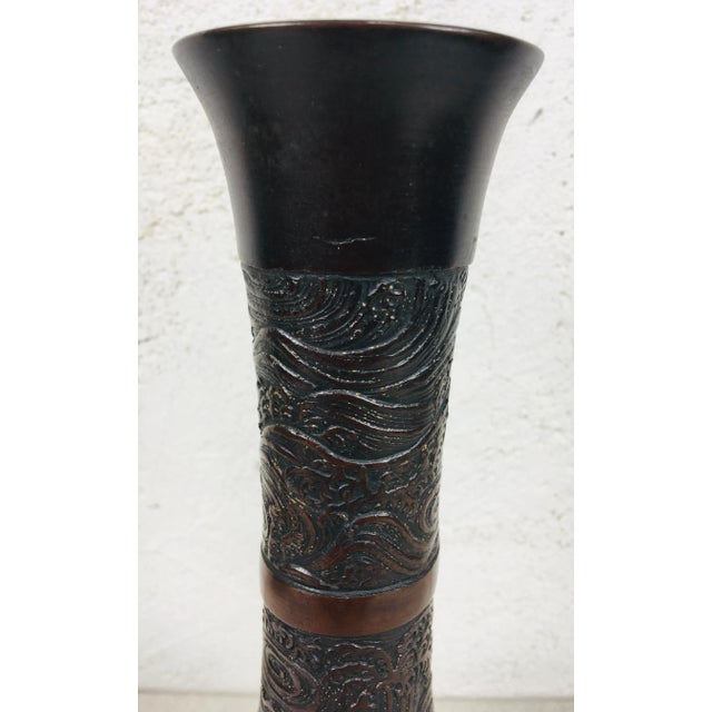 This is a mid century Asian decorative bronze vase. The bronze vase features hand chiefed scroll work on the entire...