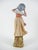 A pair of antique biscuit porcelain sculptures depicting two female figures with flowing dresses, two young girls holding...
