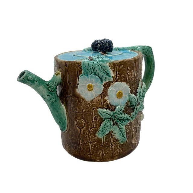 A Joseph Holdcroft cylindrical teapot and cover, naturalistically molded as a tree trunk entwined with flowering...