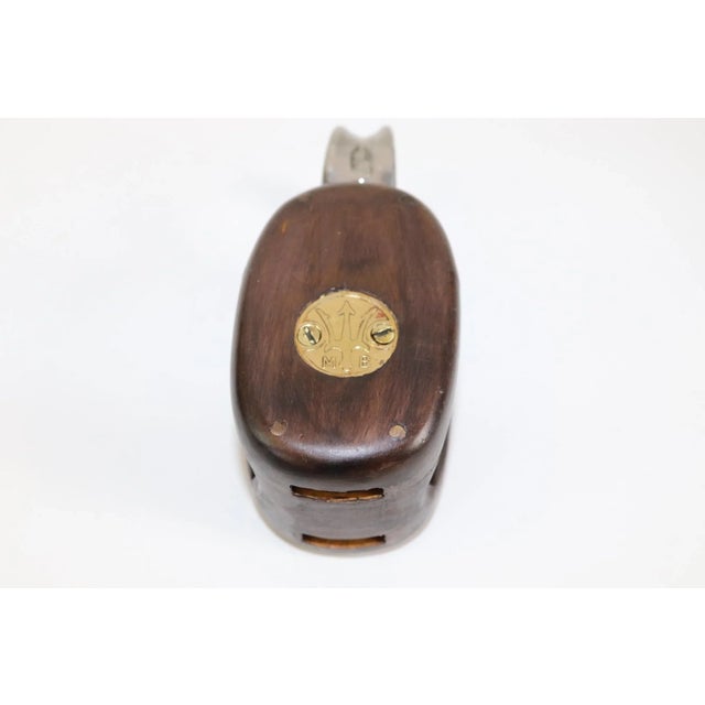 Varnished and polished yacht pulley with smooth wood finish and polished steel with brass sheave. Weight is half a pound....