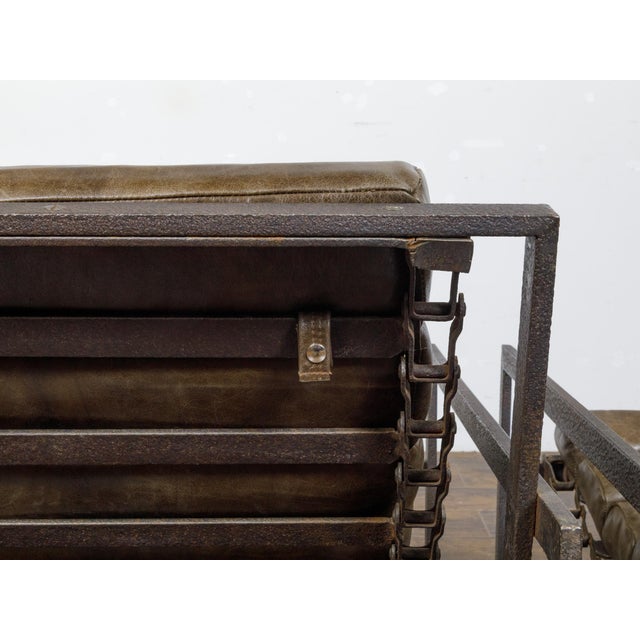 A pair of Industrial iron and leather sling transat chairs from the 20th century. This pair of 20th-century Industrial...