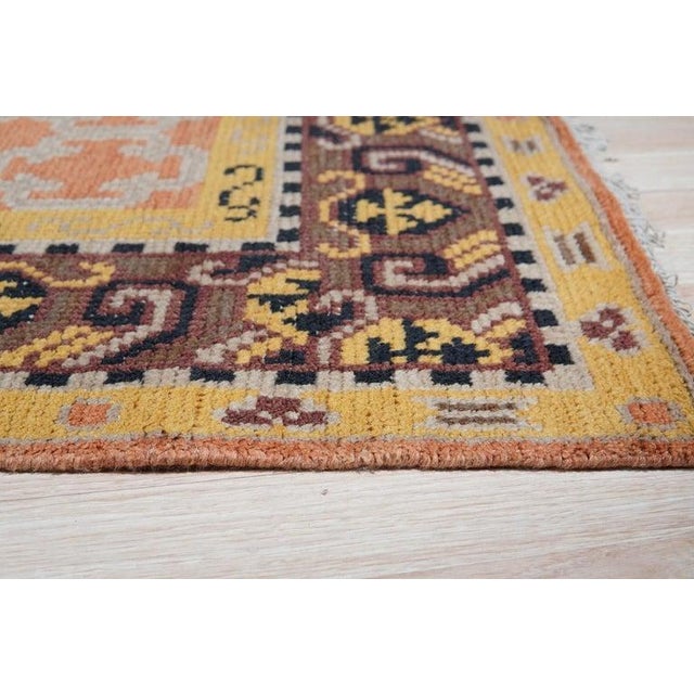 This hand knotted wool rug features a primary color palette of yellow, gold, and orange. Produced in India, the rug is...