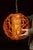 Striking mid-century pendant light featuring an outer globe of translucent amber-orange lucite formed into looping,...