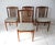 A set of four Mid Century teak dining chairs with upholstered seat bottoms and a great comfortable sculptural slat...