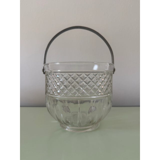 A vintage diamond-cut glass ice bucket with a silver-plated/stainless handle. Excellent vintage condition. Stainless tongs...