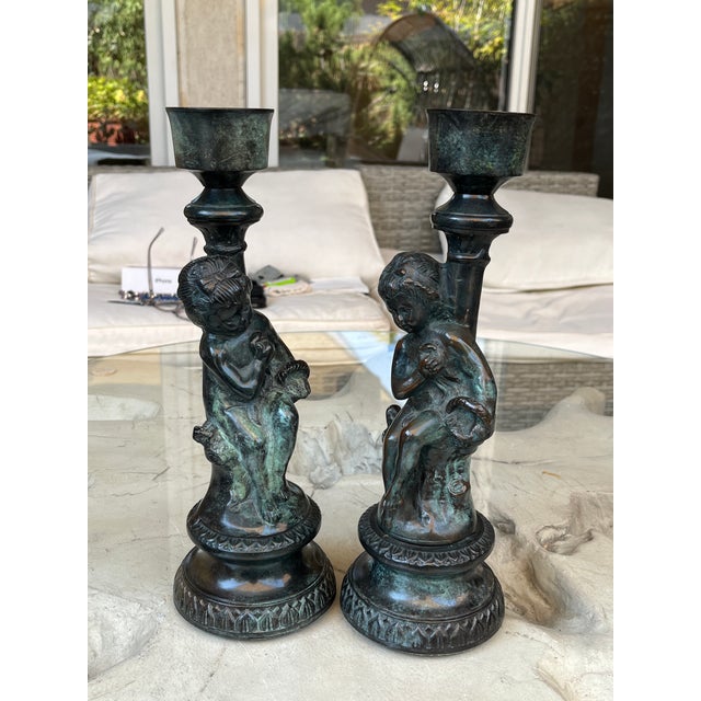 A stunning vintage pair of French Grand Tour or Renaissance Revival style figural candlesticks. Each piece features a...