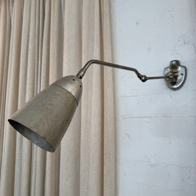 This industrial, mid-century, articulating task lamp circa the 1950s features a rugged, adjustable steel extension arm...