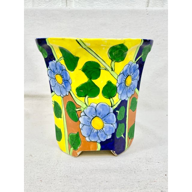 Colorful vintage planter. Made in Mexico. Features blue flowers with a colorful background. Has a hole for drainage....