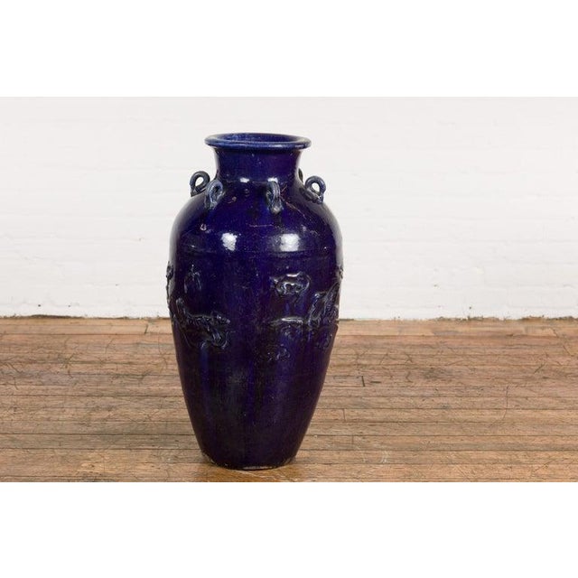 An antique Thai large cobalt blue glazed Martaban jar from the 19th century, with petite swan neck loops, raised birds and...