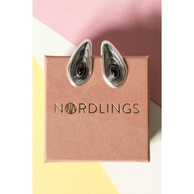 Pair of lovely earrings by Sven-Arne Gillgren, in the shape of stylized shells. Small oval garnet stones, with a deep red...