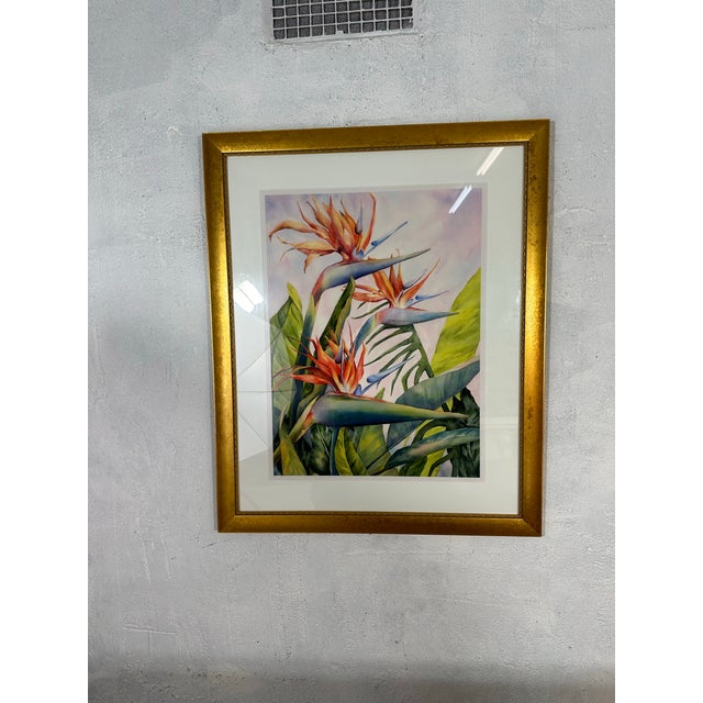 This is a large framed watercolor painting depicting tropical Bird of Paradise flowers with vibrant orange blossoms, blue...