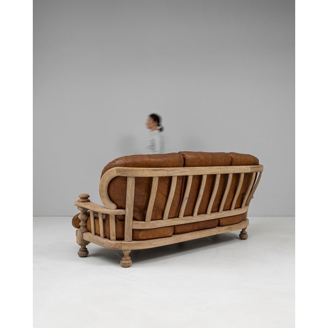 This 20th Century Belgian leather sofa combines sculptural woodworking with deep, inviting comfort, resulting in a...