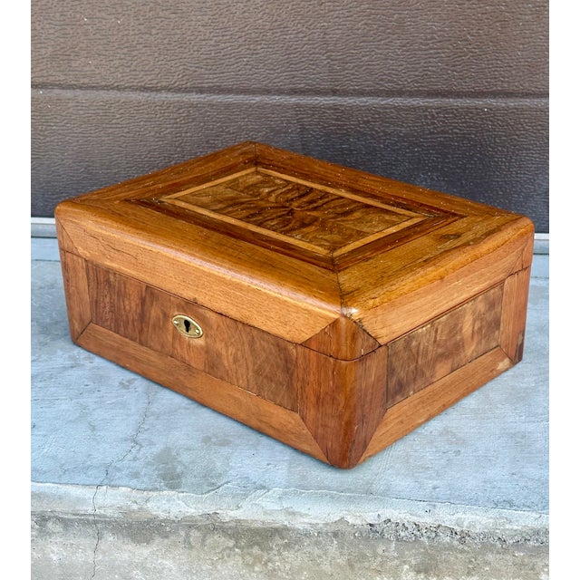 This beautiful jewelry box is made of several different contrasting veneers, including walnut and satinwood stringing. The...