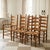 Vintage set of ten light oak ladder-back dining chairs with woven rush seats, including eight side chairs and two...