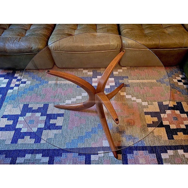 Danish circular coffee table, glass top on a finely shaped solid teak base, 1960s.