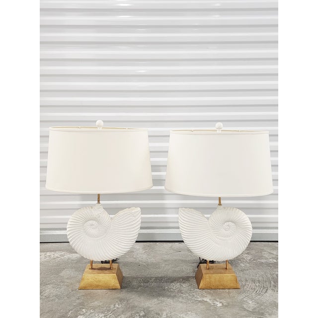 Stunning fossilized ammonite motif table lamps with gilt metal bases and oval shades. The lamps will fit in many decor...
