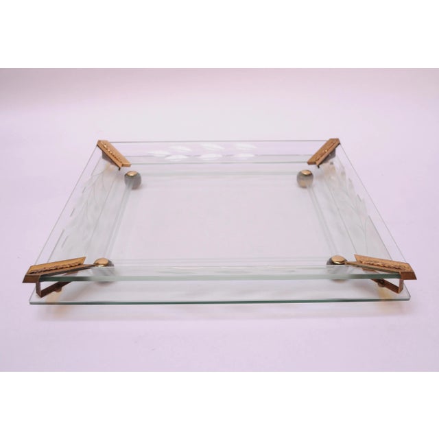 Circa 1950s deeply etched and bevelled mirrored vanity tray composed of two panels of glass separated by brass brackets,...
