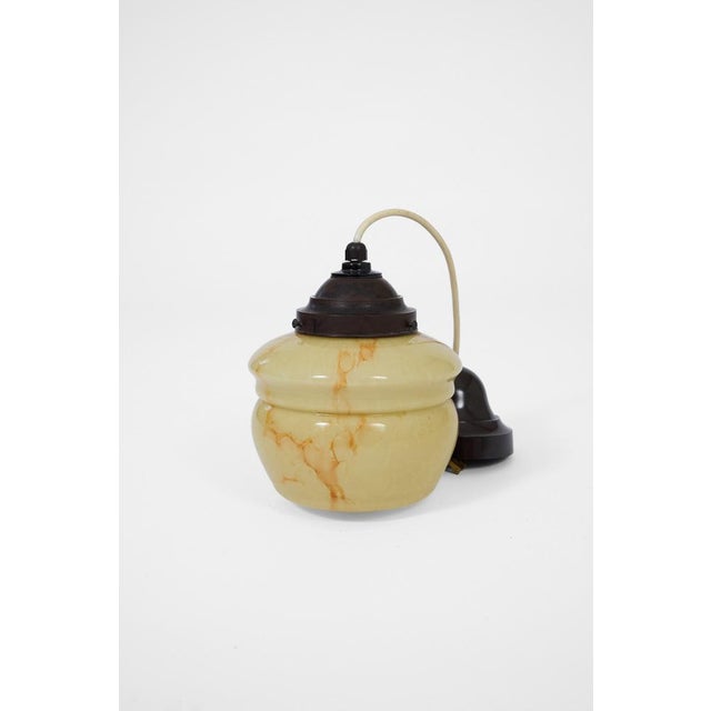 Elegant Art Deco pendant lamp featuring a softly shaped marbleized glass shade with warm amber veining and original dark...