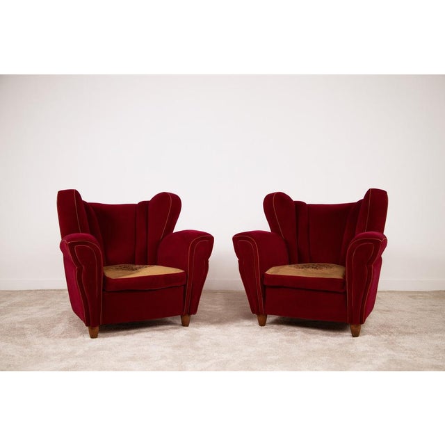 Splendid pair of 1950s club chairs in burgundy velvet attributable to Guglielmo Ulrich. Elegant in shape and comfortable...