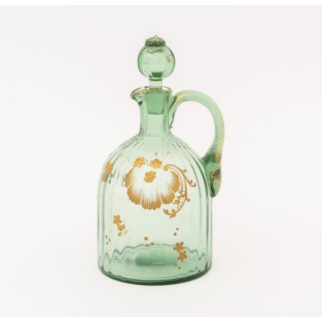 Collection of Four Gilt Hand-Painted Green Glass Vessels, comprising: a stoppered ewer, a diminutive jug, a, opaque glass...